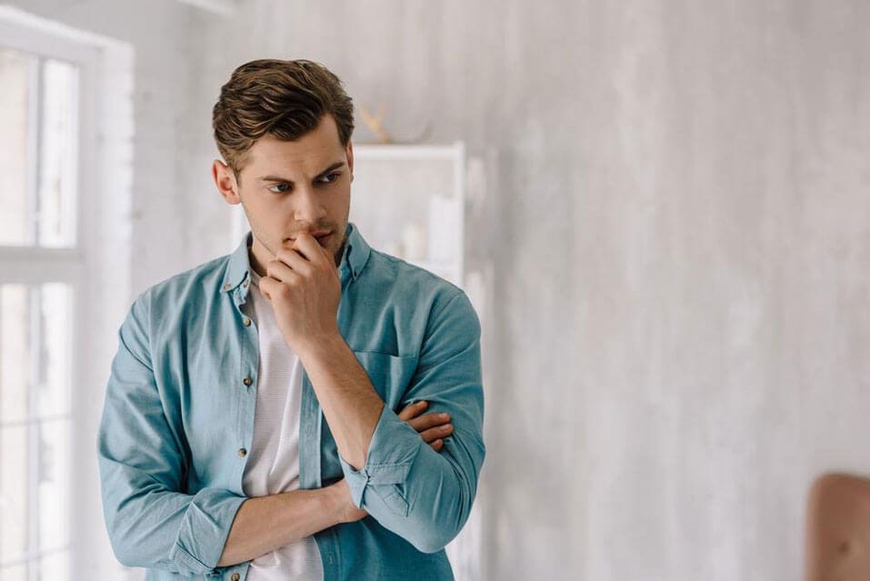 A young guy is in deep thought.