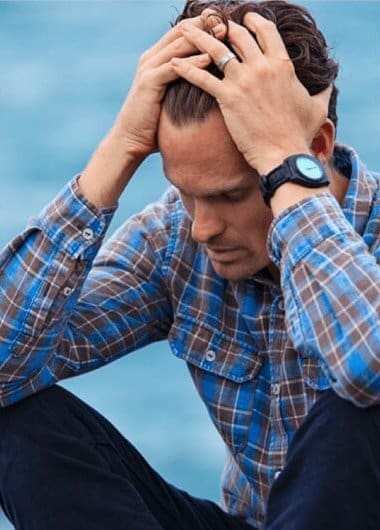 A man is holding his head and appears to be experiencing a crisis.