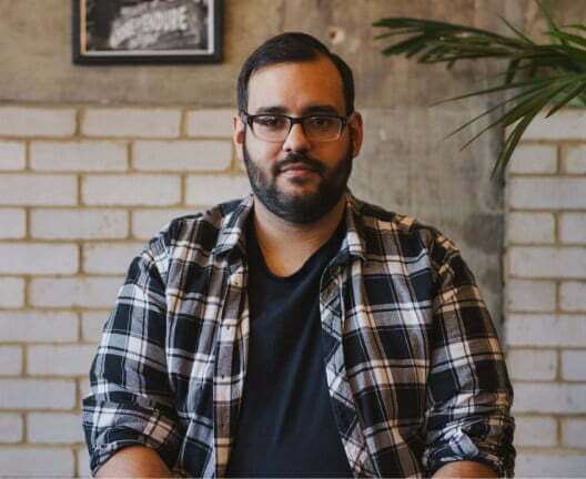 A larger-sized man is staring into the camera.