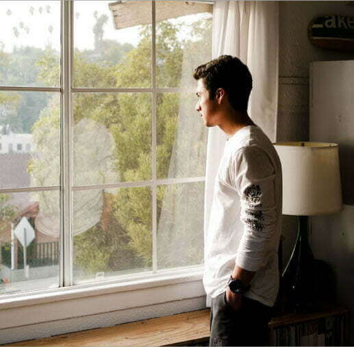 Man looking out window