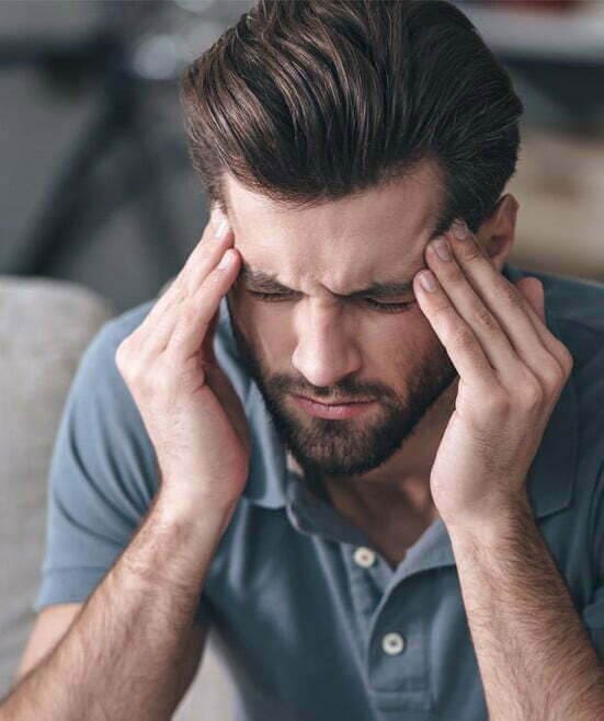Man pressing hands on his head
