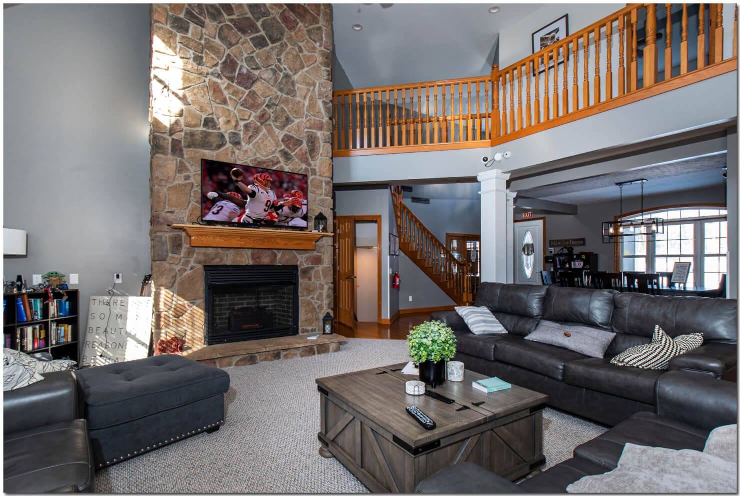 A living room with a stone fireplace and a flat screen tv, perfect for cozy evenings and entertainment.